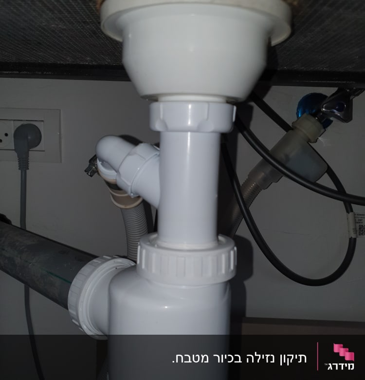 צנרת פלסטיק לבנה מתחת לכיור עם חיבורים